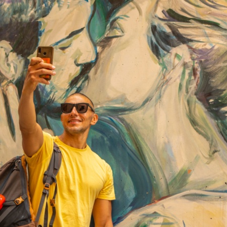Tourist taking a selfie at a graffiti in Valencia, Region of Valencia Tourist taking a selfie at a graffiti in Valencia, Region of Valencia